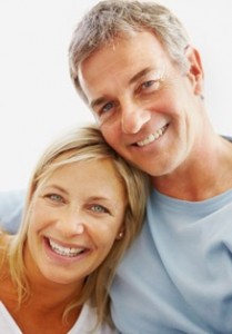 Headshot of middle aged couple happily leaning on each other
