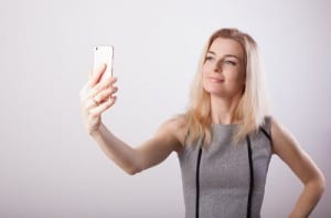 Smiling business woman making selfie photo on smartphone