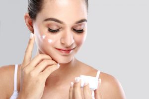 Woman Putting on Face Cream 