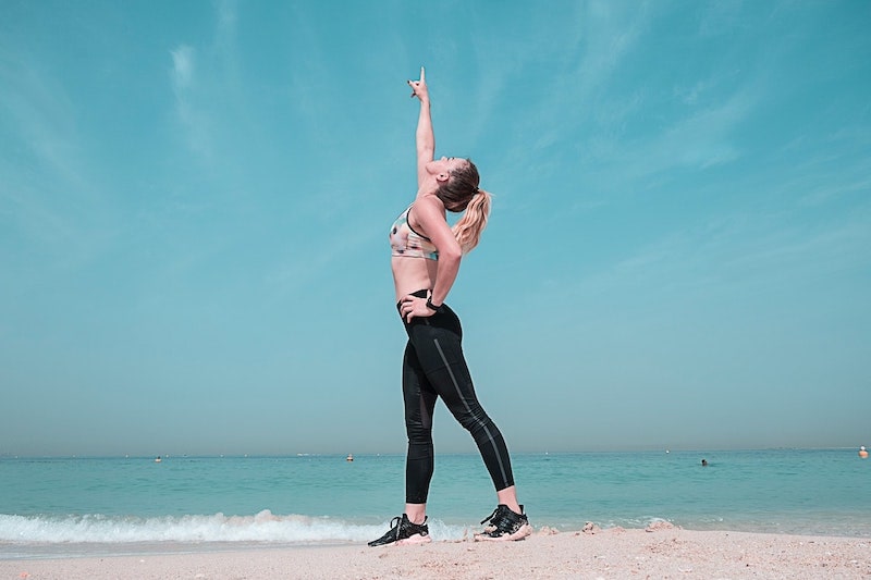 Woman pointing at the sky on a seashore