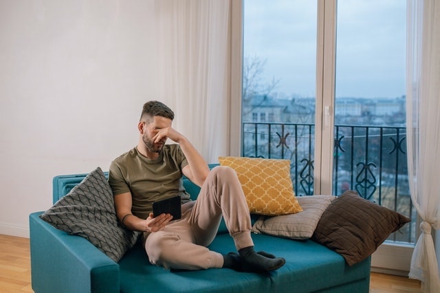 A worried man sitting on a couch