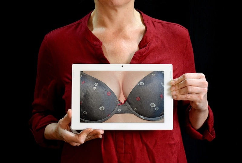 A woman holding a photo after breast augmentation