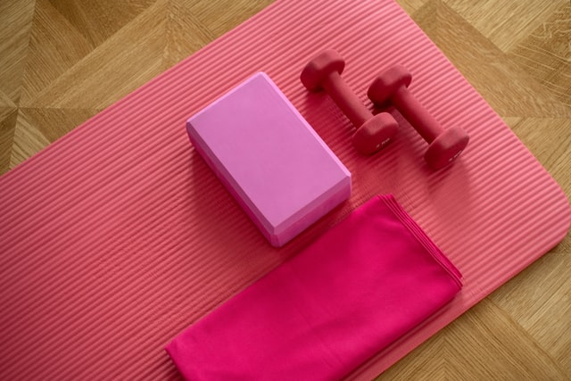 Exercising equipment, including small weights and yoga mat and blocks.