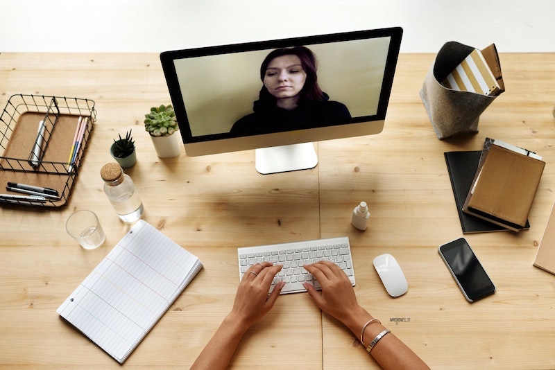 A woman using a computer that is fueling a desire for plastic surgery