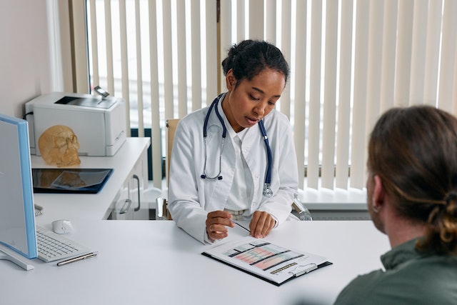 Photo of a person during a doctor's consult as a featured image for a post about things you should never lie to your plastic surgeon about