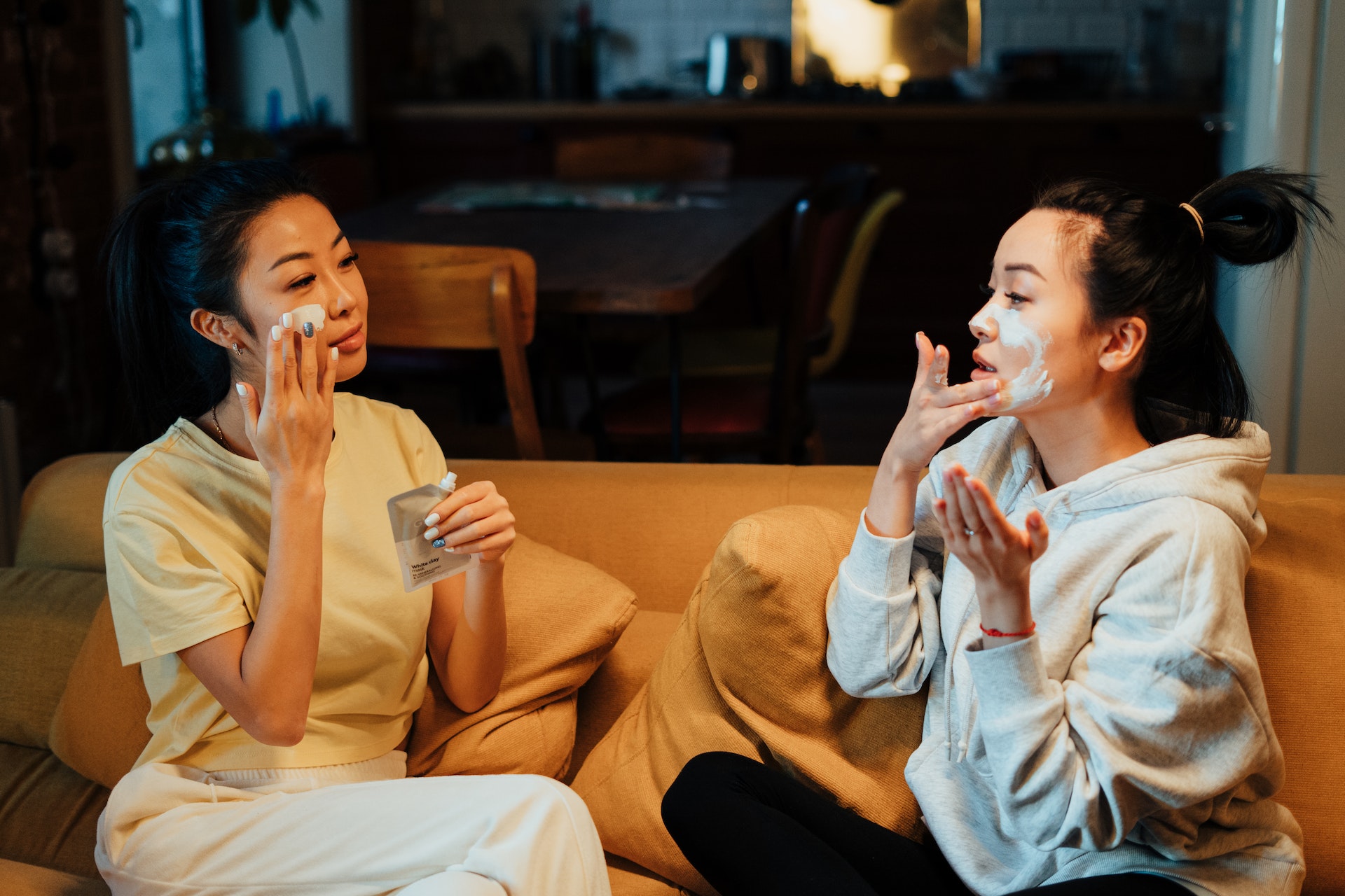 two women putting on facial cream