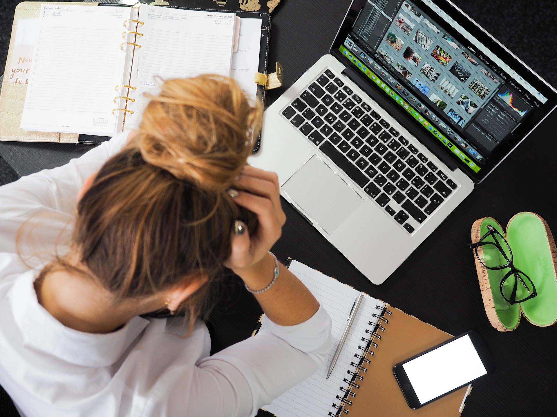 a woman sitting at her desk, working while stressed