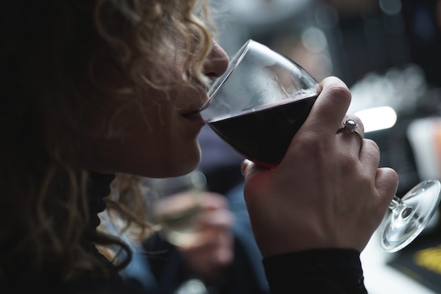 Woman sipping red wine from a big glass