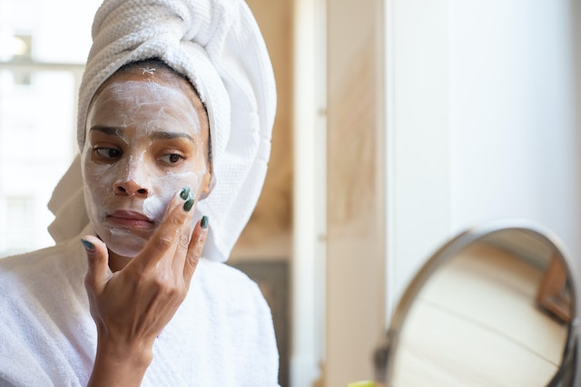 A woman putting on a face mask.