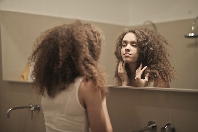 A woman looking in the mirror.
