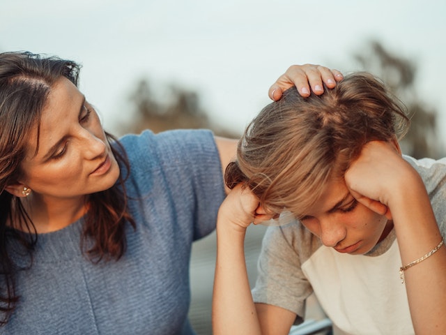 Woman talking to a teenage boy.