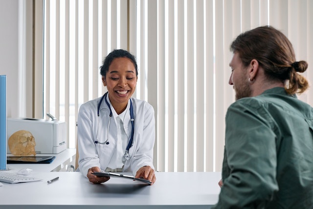 Man talking to a surgeon about factors that influence plastic surgery results