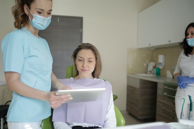 A woman discussing her surgery with a plastic surgeon.