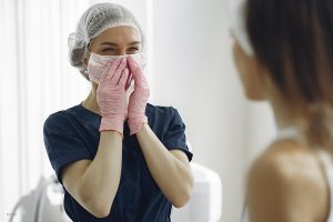 Doctor smiling while looking at a patient after plastic surgery