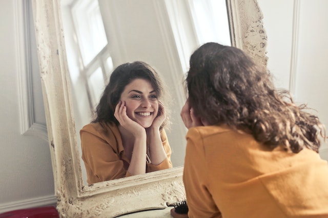 woman looking at herself in the mirror.
