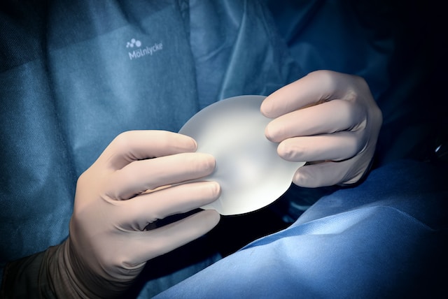 Surgeon's hands holding an implant.