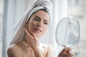 A woman looking in the mirror in the bathroom.