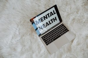 Words "mental health" written on a laptop screen.