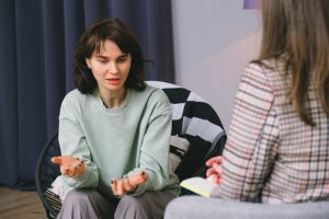 A woman discussing emotions after plastic surgery with a therapist.