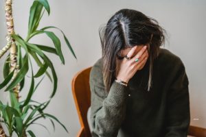 A woman sitting and feeling anxious.