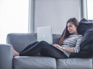 Woman sitting on a couch and using her laptop.