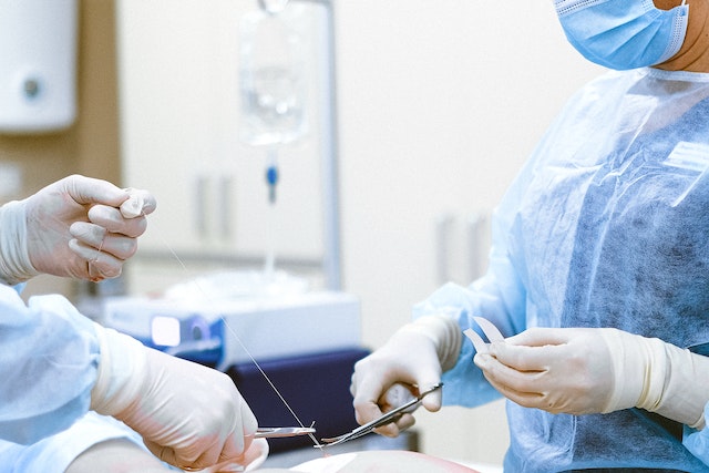 Two people with gloves on their hands holding medical equipment