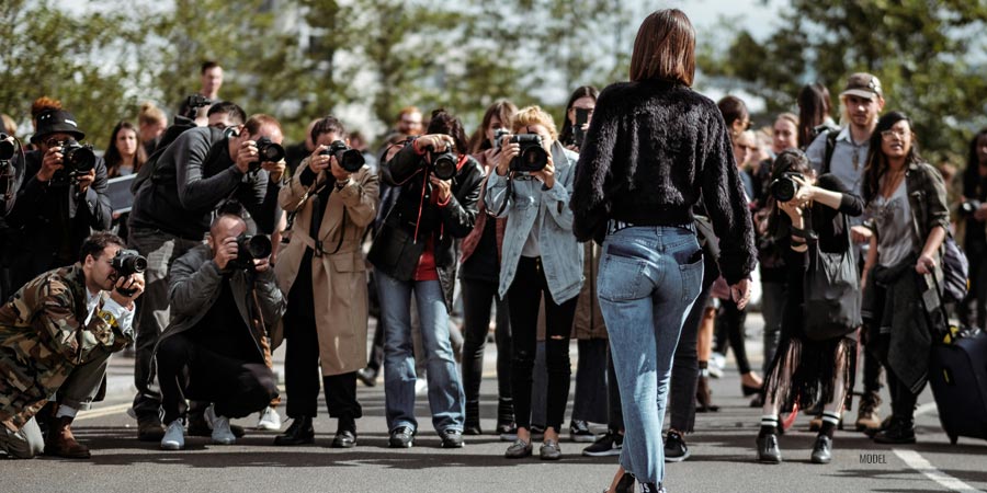 A large group of paparazzi photographing a woman