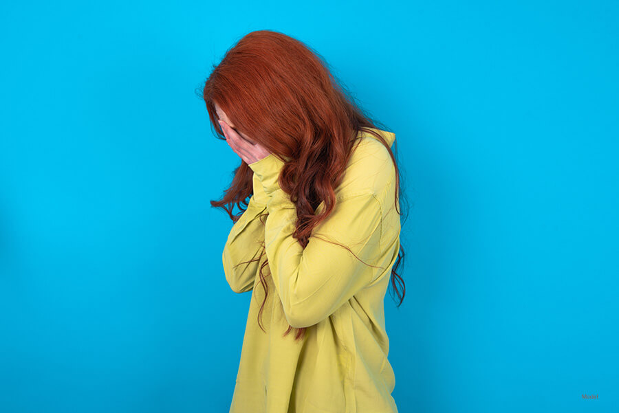 Woman hiding her face with her hand