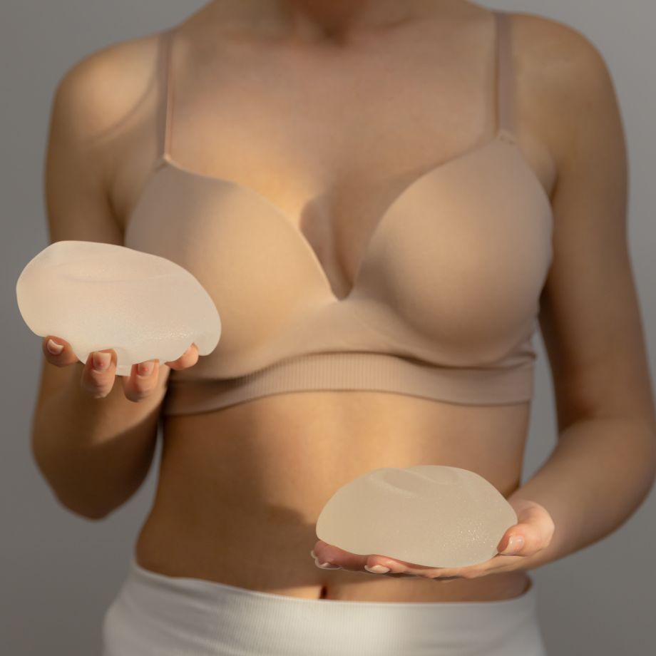 woman holding breast implants